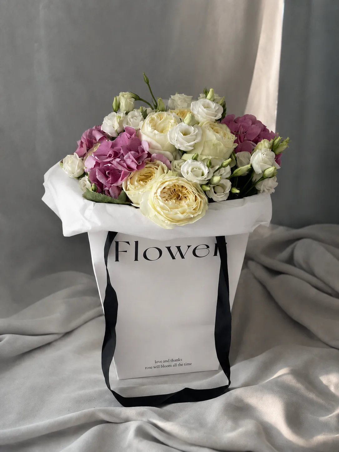 Pink hydrangea, cream garden roses and lisianthus in a luxury flower bag - flower delivery in Prilep